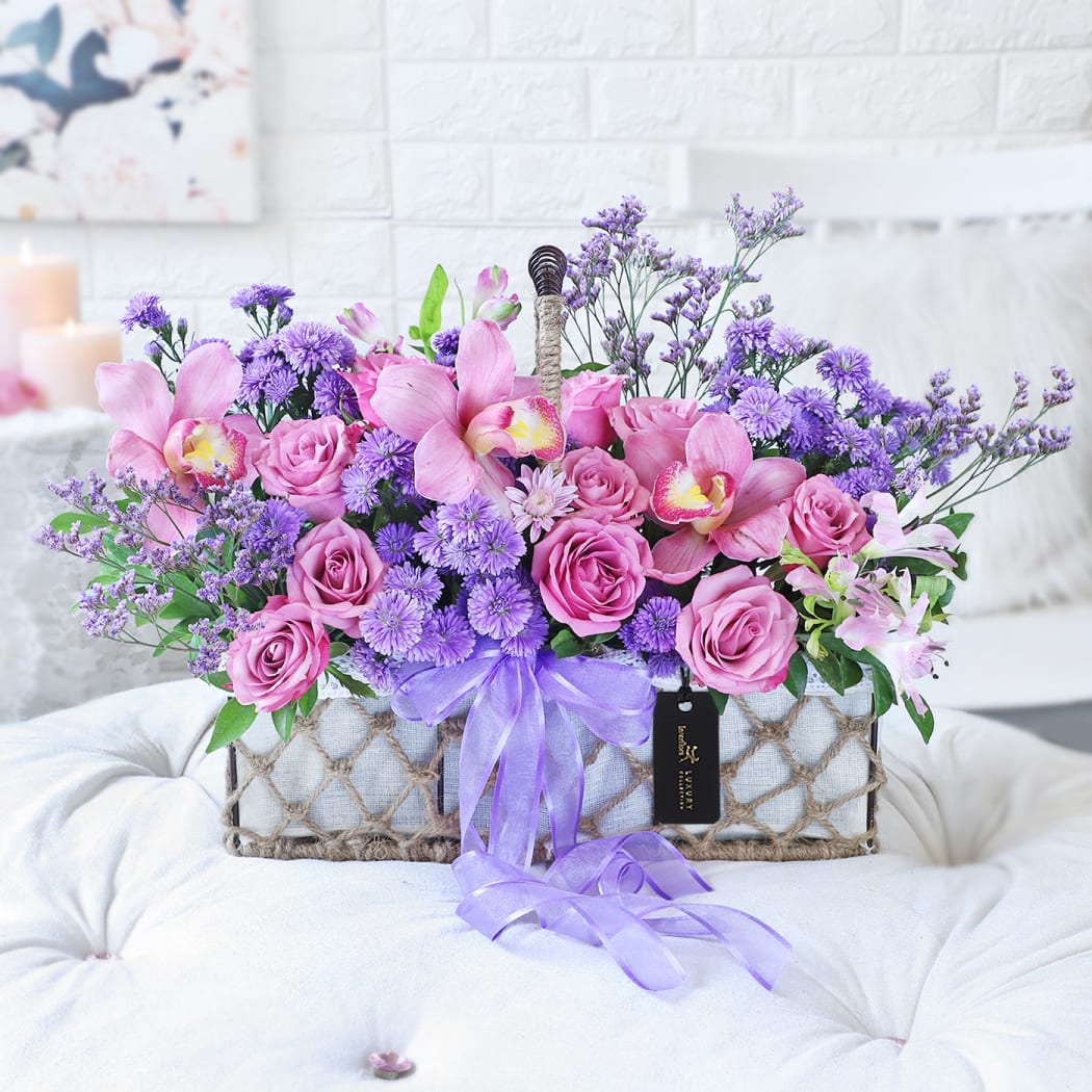 Floral gift basket with roses orchids and purple flowers